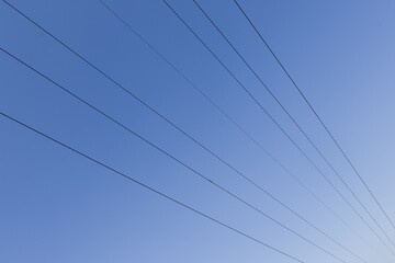 Fototapeta premium High voltage columns, in the background with blue sky and clouds. Prices of electricity, consumption, ecology.