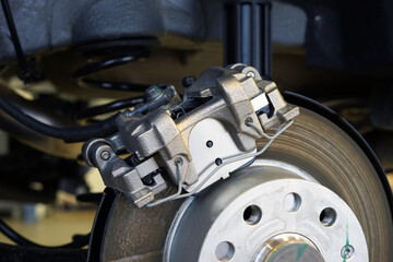 Brake caliper mounted on a brake disc close-up. Selected focus.