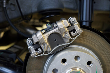 The braking system of a modern car. Brake caliper installed on the car. Car service, auto parts.