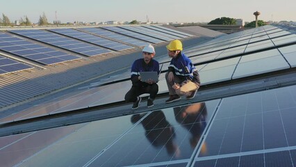 Aerial asian engineer service meeting and checking solar cell on the toproof of factory. Worker technician inspection and repair solar cell panels. Green energy, ecology and alternative power concept - Powered by Adobe