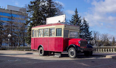 Old retro red bus in Europe. Rusty rough metal surface texture. Antique vintage soviet automobile bus. Side view.
