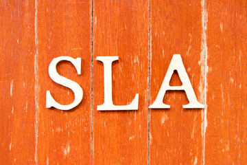 Alphabet letter in word SLA (Abbreviation of Service level agreement) on old red color wood plate background