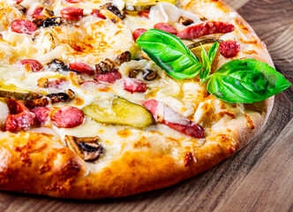 Pizza with Mozzarella cheese, salami, chicken meat, beef, ham, Tomato sauce, pepper, spices. Italian pizza on wooden background