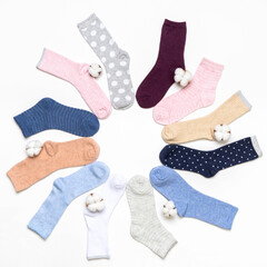 Various modern trendy women's cotton socks set with cotton flowers on white background. Fashionable socks store. Socks shopping, sale, merchandise, advertisement concept