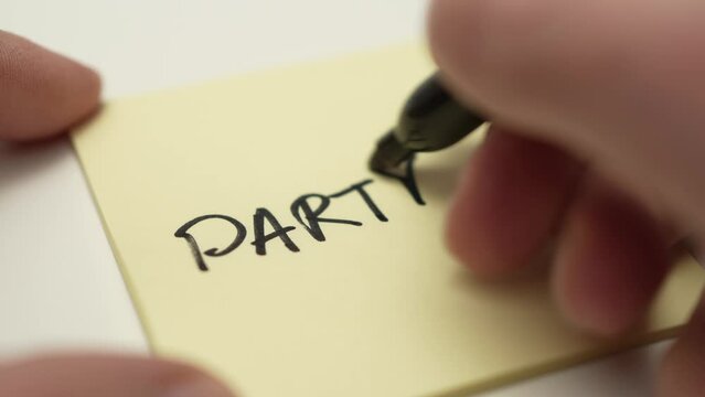 PARTY Hand Writing on a Paper Sticky Note Message Closeup