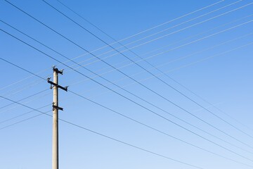 High voltage columns, in the background with blue sky and clouds. Prices of electricity, consumption, ecology.