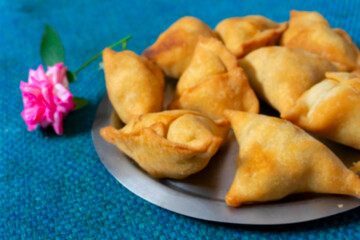 Blurred image of homemade Samosa, samsa or smosa. A vegetarian spicy Indian special traditional street food. Iftaari dish, Selective focus.