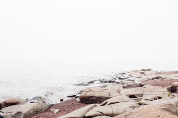 Large flat rocks on the shore of Lake Superior on a foggy and overcast day