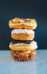 Four color donuts stacked in front of a black background