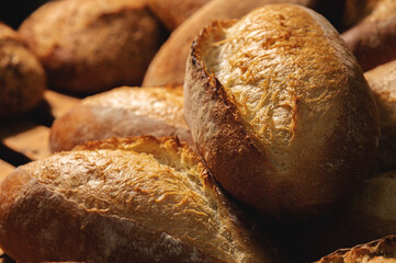 Sourdough bread close-up. Freshly baked round bread with golden crust on bakery shelves. The context of a German bakery with a rustic assortment of bread.