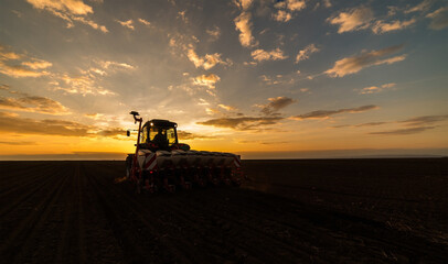 Naklejka premium Farmer with tractor seeding