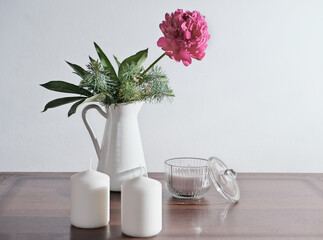  lifestyle interior decoration pink peony flower with candles on rustic wooden table. cozy home concept. morning light. spring flowers grown in a garden.