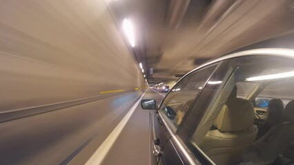 Motion time-lapse car driving in tunnel Paris skyline view at night. Hyper-lapse side view from the car window driving at night in the tunnel, Paris skyline view 