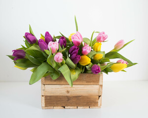pink, yellow ans purple tulips in wooden box