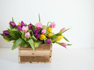 pink, yellow ans purple tulips in wooden box