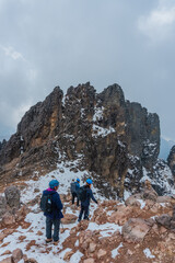 Fototapeta premium Group of hikers ascending on snow-capped mountain peak