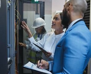 Run me through this again. Shot of two workers inspecting the electronic equipment in a server room together at work.