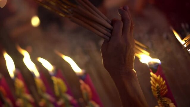 Close up hand burn the joss stick at temple during Chinese new year