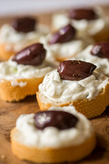 Piece of bread with tzatziki spread and olive fruit