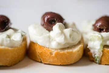 3 small piece of bread with tzatziki spread and olive