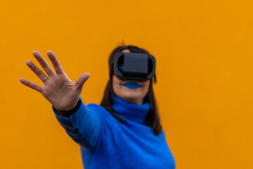 woman playing with a virtual reality camera on yellow horizontal background