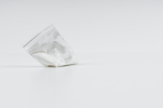 Cocaine in a plastic bag on a white background with copy space.