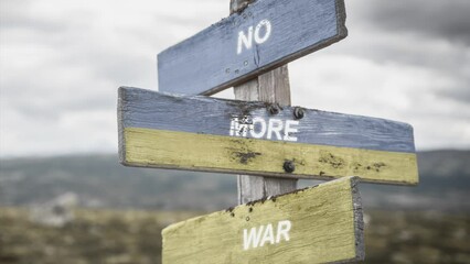 no more war text quote on wooden signpost outdoors, written on the ukranian flag.