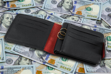 Save money for honeymoon, wedding trip with rings on wallet with money