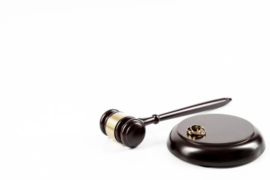 Wedding rings on the figure of a broken heart from a tree, hammer of a judge. Divorce divorce proceedings. Judge hammer wedding ring with copy space