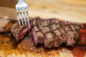 Medium rare meat on wooden plate