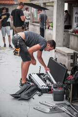Behind the scene. Filmmaking lighting technician adjusting and setup lights