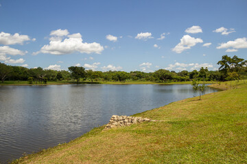 Paisagem de um parque muito arborizado e um lago, na cidade de Goiânia. Parque Leolidio di Ramos Caiado.