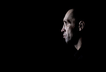 Brutal man in a black shirt on a dark background