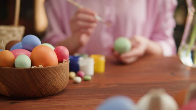 Happy Easter holiday. Coloring eggs close-up. Woman preparing for Easter, painting and decorating eggs. Christian celebration, family traditions.