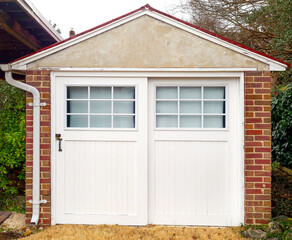 Old fashioned brick garage with wooden doors.