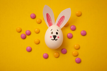 Food photo for Happy Easter. Chicken eggs with cute bunny faces and bunny ears and yellow and pink...