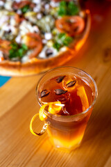 cocktail with orange on the table with pizza