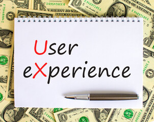 UX user experience symbol. Concept words UX user experience on white note. Metallic pen. Dollar bills. Beautiful white background. Copy space. Business and UX user experience concept.