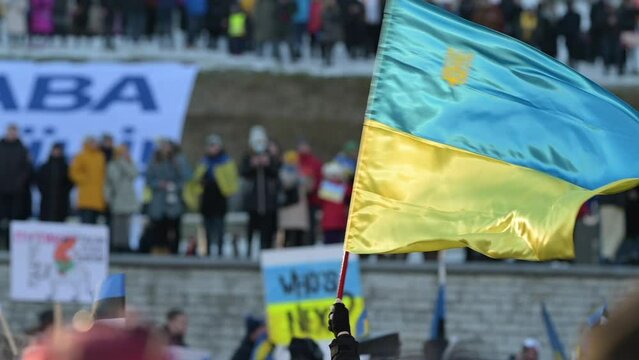 Activist or protester holding a Ukrainian flag at a public demonstration or meeting supporting Ukraine in Estonia, Tallinn