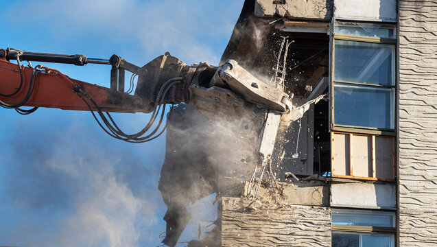 building being demolished by machine