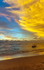 Fototapeta premium Summer evening landscape on the sandy shore of the Indian Ocean with boats against the sky with clouds illuminated by the sun at sunset. Sri Lanka