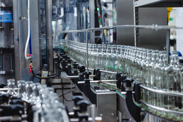 Production line transports empty glass bottles for alcohol