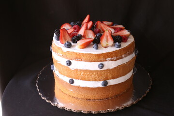 Beautiful home wedding cake decorated with strawberries and blue berries
