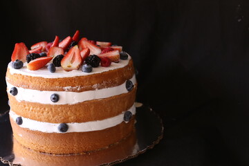 Beautiful home wedding cake decorated with strawberries and blue berries