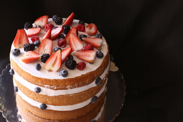 Beautiful home wedding cake decorated with strawberries and blue berries