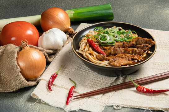 homemade traditional taiwanese pork noodle with pork broth and seasoning with spicy,tomato,onion,leek,garlic and ginger.