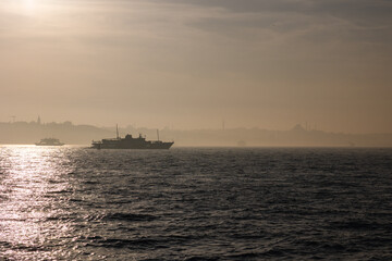 Istanbul background. Silhouette of Istanbul and a ferry at foggy weather