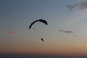 Paragliding silhouette, paraglider pilot fly in sky on beauty nature beach sky background,...
