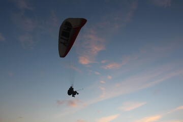 Paragliding silhouette, paraglider pilot fly in sky on beauty nature beach sky background,...