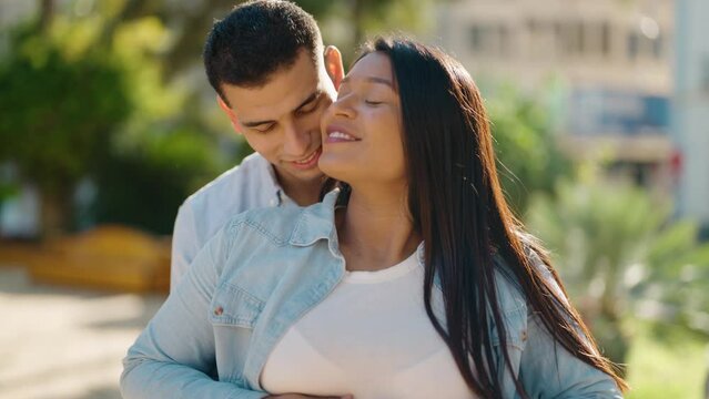 Young latin couple smiling confident touching belly standing at park